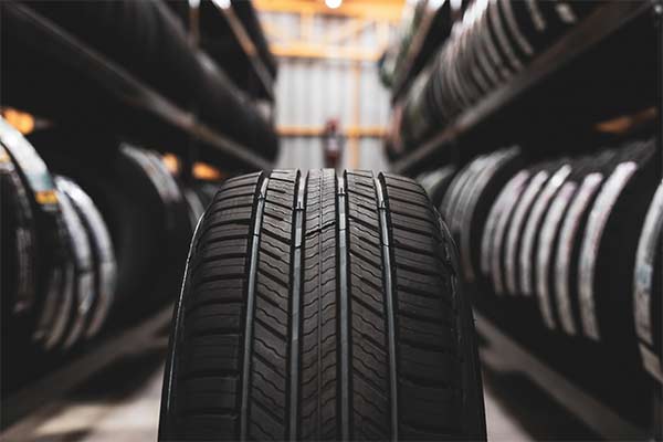 A new tire is placed on the tire storage rack in the car worksho